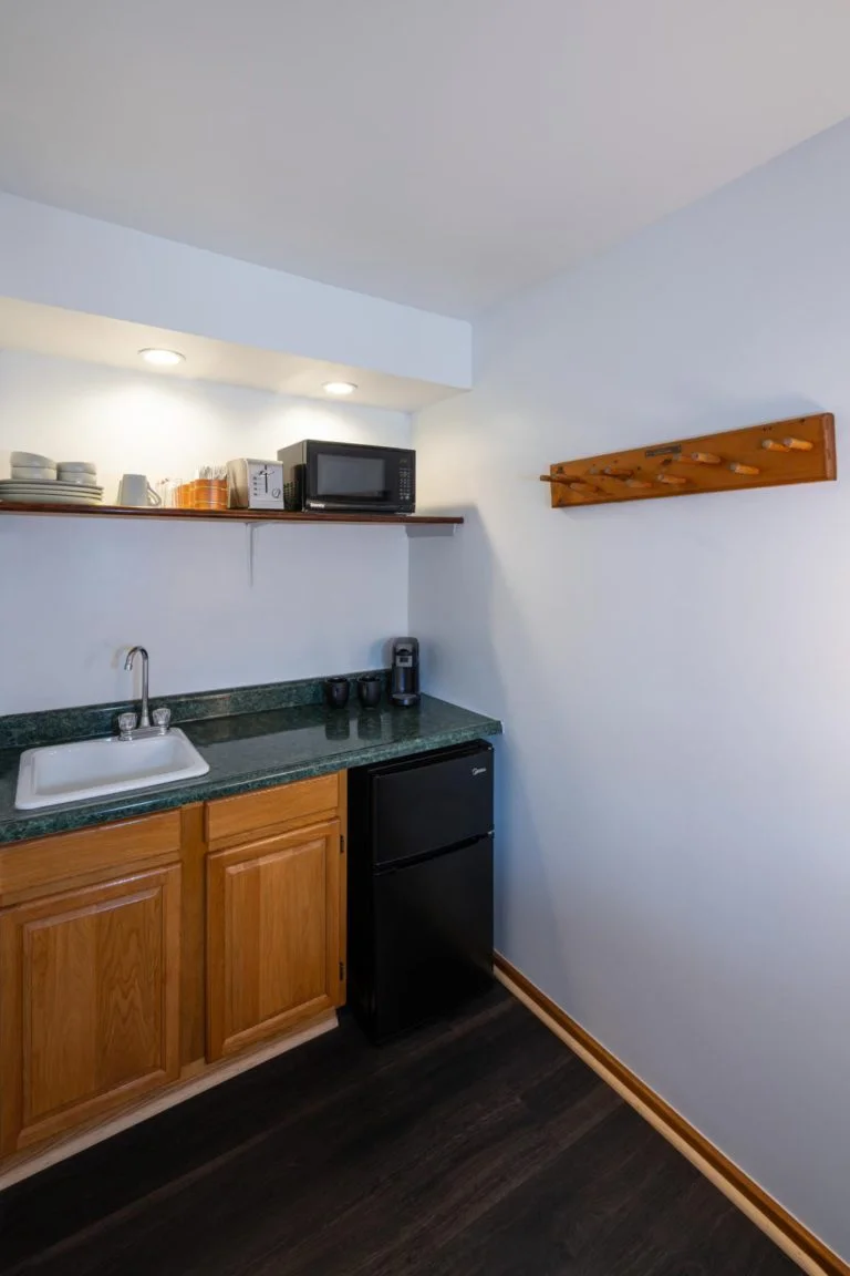 A kitchen with a sink and a microwave.