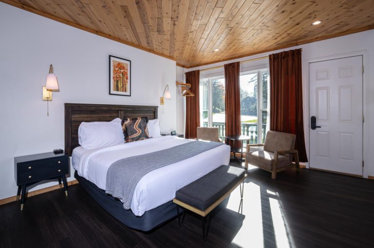 A bed in a room with wood ceilings.