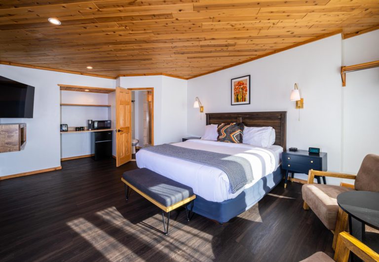 A room with wood ceilings and a bed.