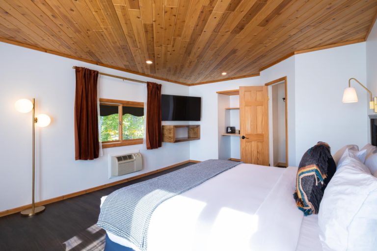 A room with wooden ceilings and a bed.