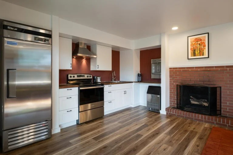 A kitchen with a stainless steel stove and a brick fireplace.