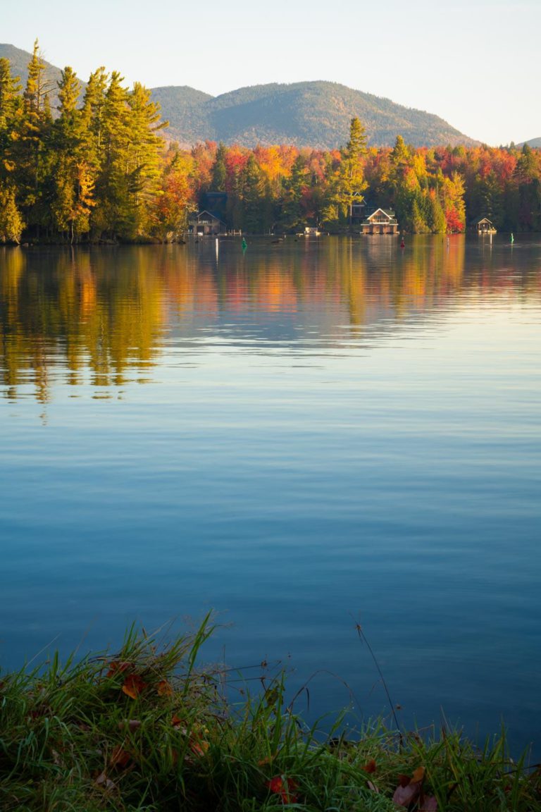 A lake surrounded by trees and fall foliage.