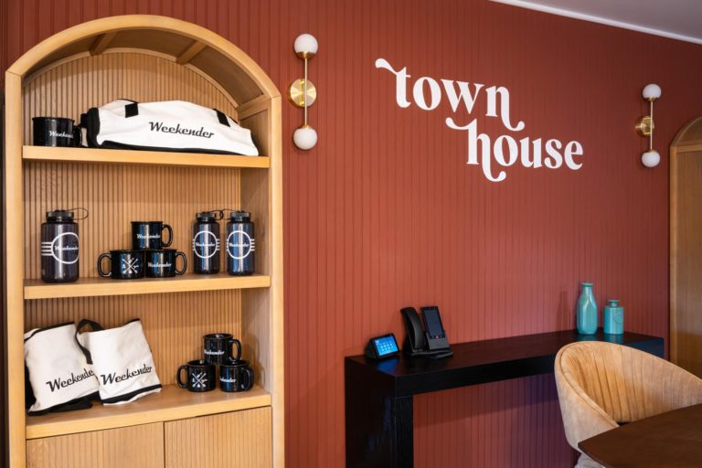 A room with a table and chairs and a wall that says town house.