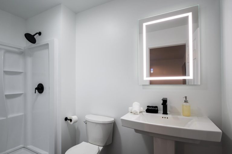 A white bathroom with a sink, toilet and mirror.