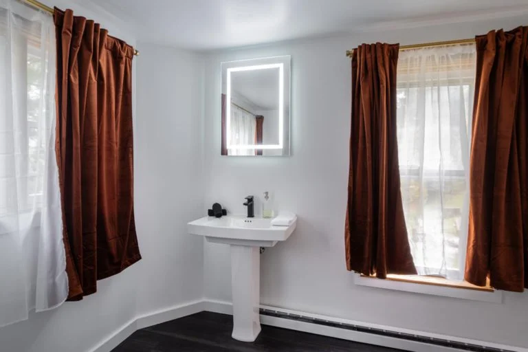 A bathroom with brown curtains and a sink.
