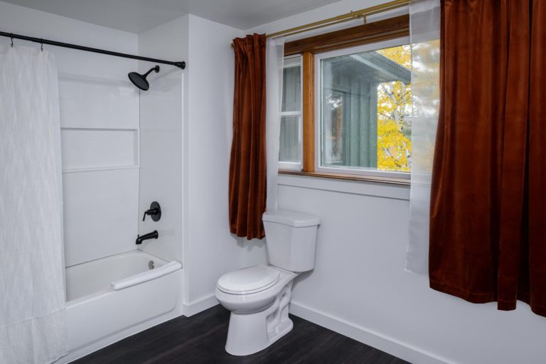 A bathroom with a toilet and a window.